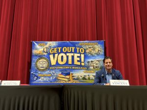 John Gregory Vincent sits at an NAACP candidate forum beside an empty place marked for Congressman Russell Fry.